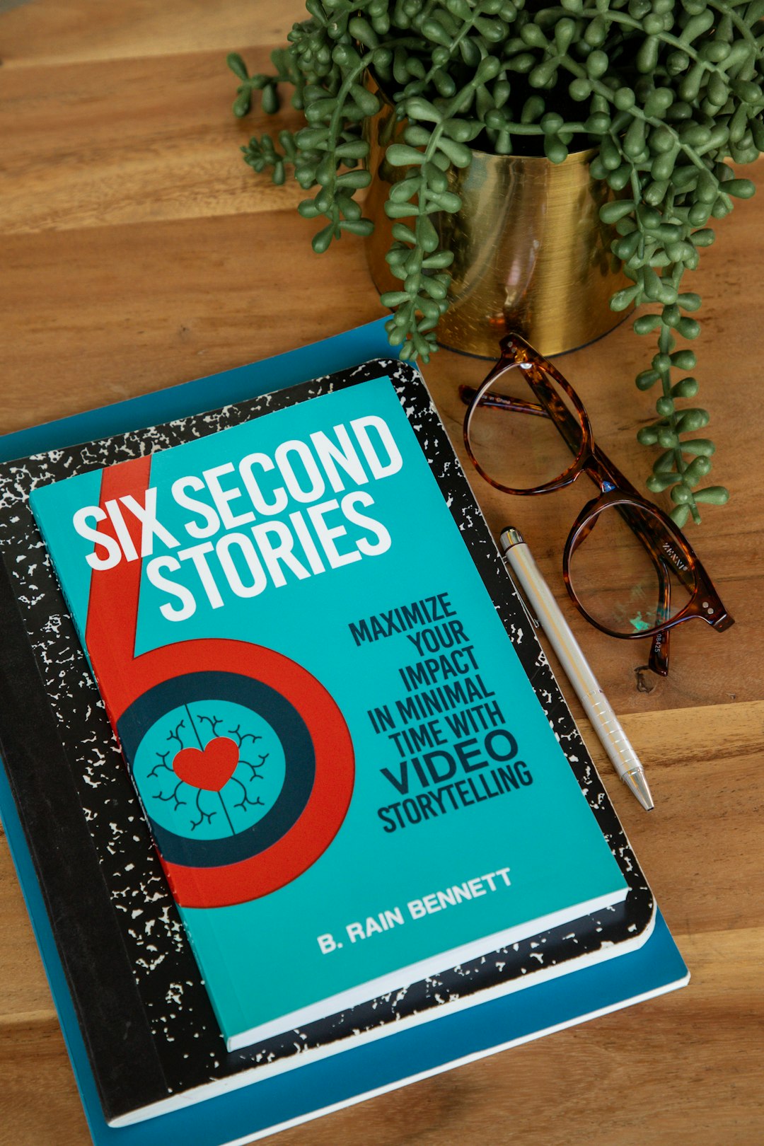 A storytelling book and notepad, with pen and glasses.